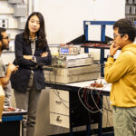 Jungwon in her lab, having a conversation with two graduate students.