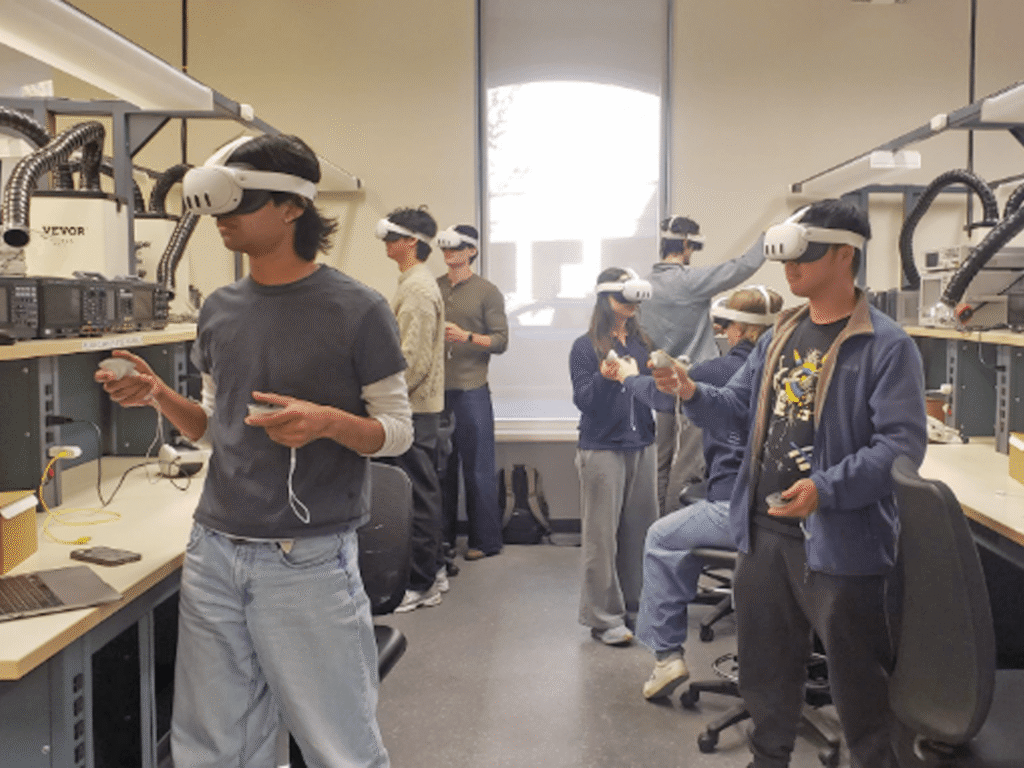 Students standing in lab wearing virtual reality headsets and holding controllers in their hands.